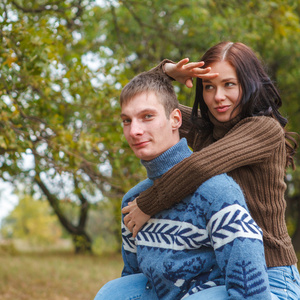 女孩坐在后面的一个家伙。一对夫妇在公园里的爱