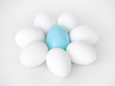 照片的一个可爱的花朵形状的安排, 白色的鸡蛋作为花瓣和一个蓝色的塑料复活节彩蛋在中心创造一个伟大的假日背景图像
