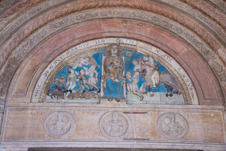 美丽的门户超越了一个半月形, 在其中你可以看到一个多彩的浮雕描绘的圣母宝座与孩子, 周围的麦琪和牧羊人