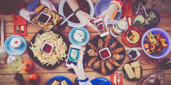 顶视图的组人一起吃晚饭,坐在木桌