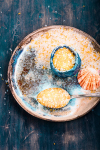 彩海盐在碗和勺子放在老陶器板上