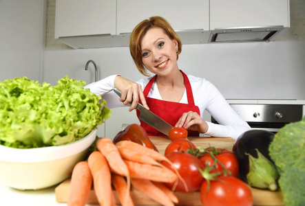 幸福的女人在家厨房用lettu准备蔬菜沙拉