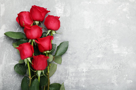 灰色木桌上的红玫瑰花束