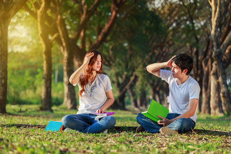 男人和女人坐在公园里看书