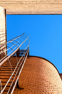 建设工业梯子，蓝色的天空和砖墙壁
