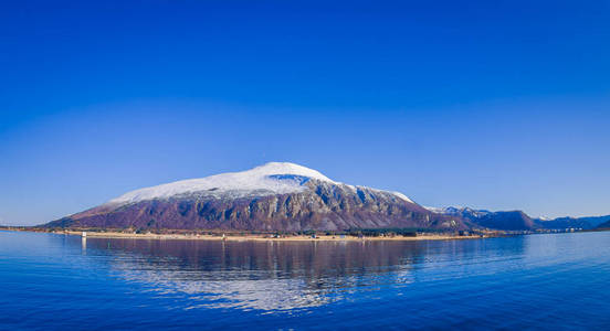 挪威山脉的户外景观。挪威 Hurtigruten 地区覆盖部分积雪的美丽山脉