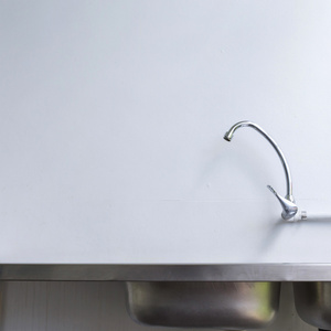 不锈钢水槽，水龙头在白色的厨房的房间