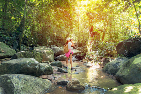 亚洲旅行摄影师女性在泰国的深森林中拍摄瀑布照片。旅游理念