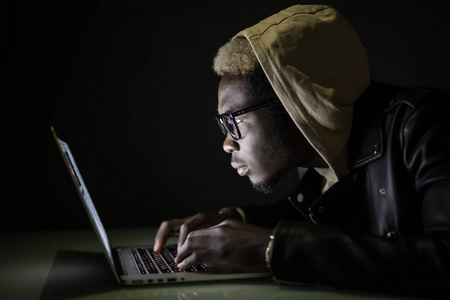 非洲人在黑暗中玩游戏.美国黑人黑客攻击服务器在夜间照片