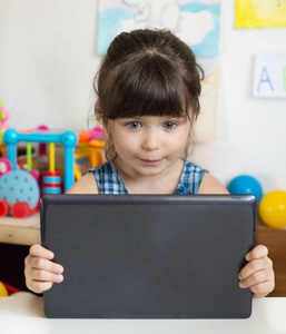 学前儿童4或5岁女孩在家里或幼儿园玩平板电脑。学校儿童教育理念