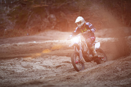 摩托车越野赛，耐力赛骑手在土路上。极端的越野比赛。硬耐力赛摩托车。在他身后的森林