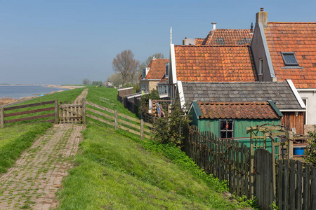 传统的房子沿堤在 Makkum, 历史荷兰村庄