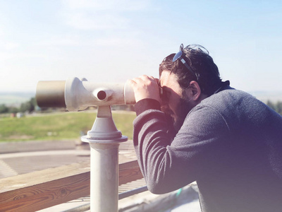 游人在望远镜塔观众在城市看法看。塔式查看器是一个很受欢迎的设备看城市