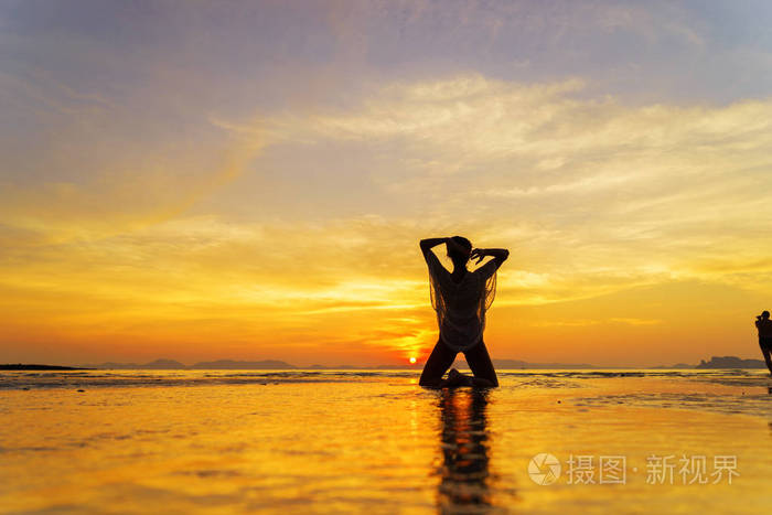 美丽的女人在日落时在泰国海边