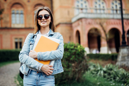 smartyoung 大学校园里的女大学生手里拿着笔记本