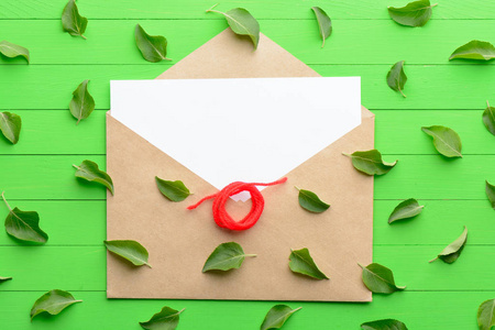 一张空白的纸信封上绿色木背景