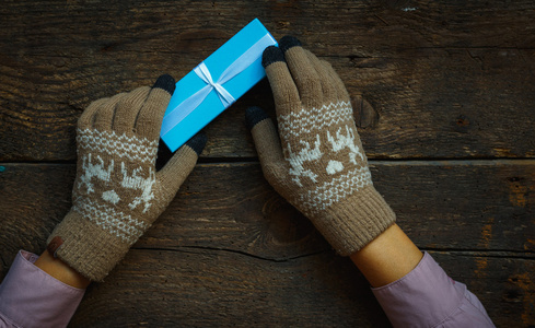 在圣诞礼品盒冬季手套的手