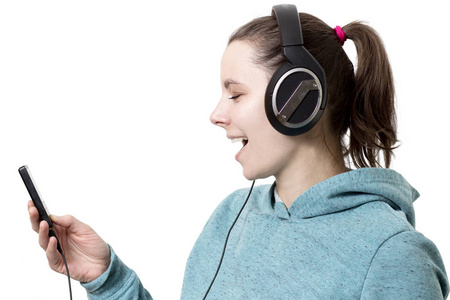 女人听现代音乐.用耳机和播放器唱歌.音乐爱好和声音照片