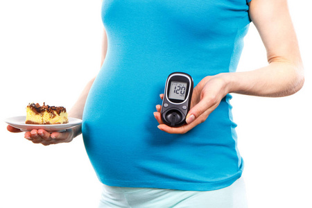 孕妇测血糖血糖仪和一块芝士蛋糕, 糖尿病和糖水平在怀孕期间孕妇照片