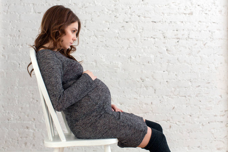 怀孕的女性，坐在椅子上摆姿势