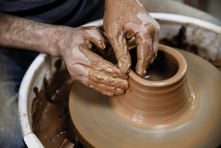 陶器。陶匠车轮上的主人, 生产一艘粘土容器