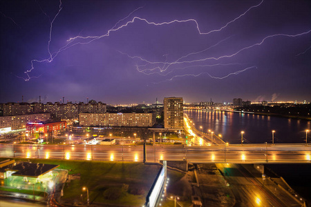 对城市夜景观，如强的闪电，在风雨交加的深夜，戏剧性的天空，雨在夜间的城市建筑严重闪电风暴晚上镇上的壮丽景色很大闪电