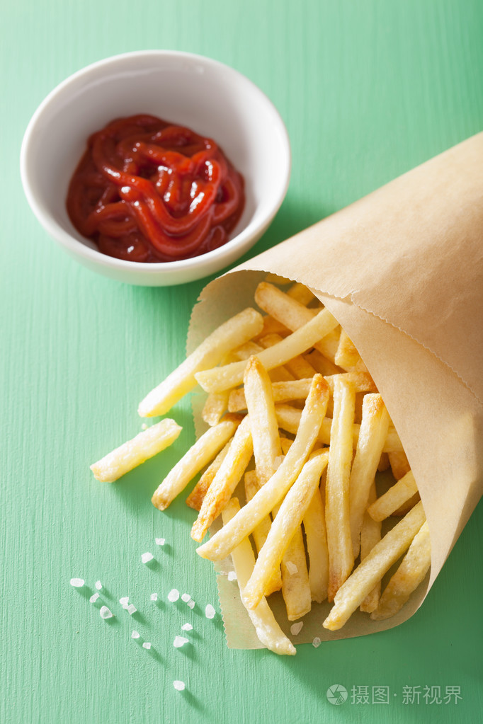 炸薯条与番茄酱在绿色的背景