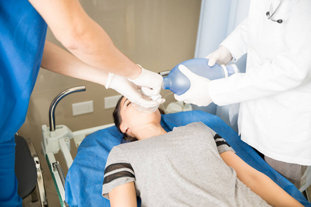 急诊室无意识患者使用面罩置于患儿袋通气的医生特写照片