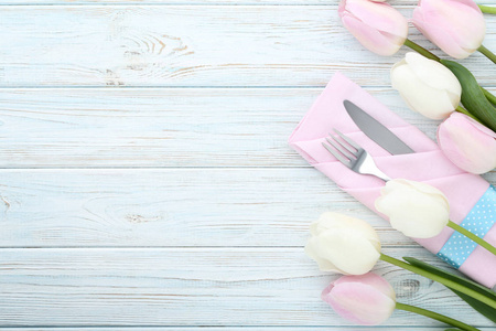木桌上有餐巾和郁金香花的厨房餐具