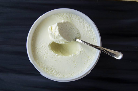 在桶里的酸奶，酸奶发酵酸奶的勺子采取