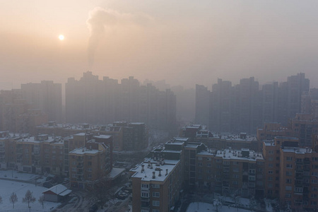 日落时建筑的城市景观与空气的排放