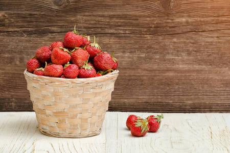 篮子成熟的草莓在一个木质的背景。文本空间