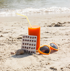 医疗丸 胡萝卜汁和太阳镜上沙子在沙滩 维生素 A 和美丽，持久的棕褐色