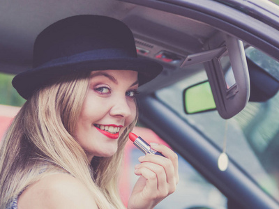 年轻女人口红在汽车中的应用