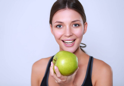 幸福的年轻女人吃苹果，在白色背景上孤立
