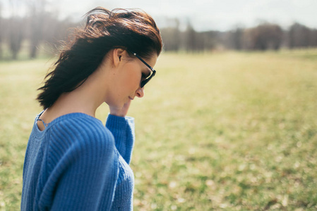 背面的画像美丽的年轻的黑发妇女与风吹头发的自然背景.