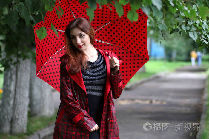 一件雨衣和一把雨伞的女人