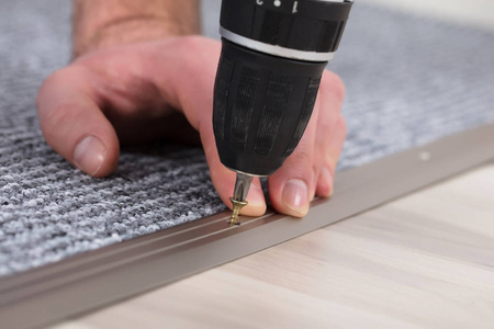 地毯钳工手安装灰色地毯用无线螺丝刀特写