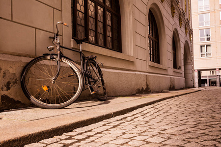 老棕褐色的老式自行车人行道上墙石头户外毁了窝