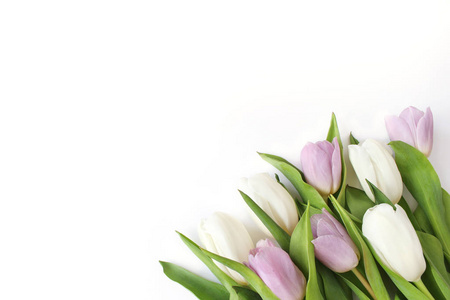 春季风格的股票照片。复活节的概念。女性桌面场景, 白色和紫色的郁金香花花束在白色的桌子背景。空的空间。平躺, 顶部视图