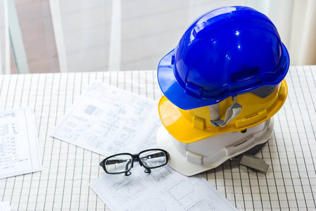 白色, 黄色和蓝色坚硬安全帽帽子为技工的安全项目作为工程师或工作者, 在混凝土地板, 设备, 工业, 建筑