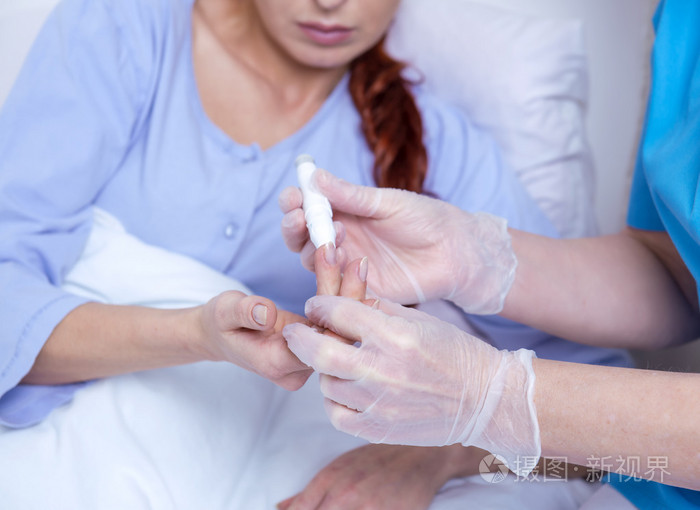 女性病人躺在医院的床上和交谈的护士