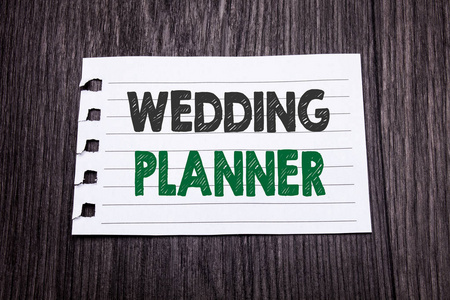 字, 写婚礼策划人。婚姻准备的商业概念写在粘纸上的暗木背景。黑色和绿色