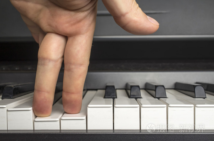 用手指在钢琴键上按一下