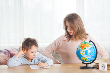 年轻母亲在家学习地理与儿子图片
