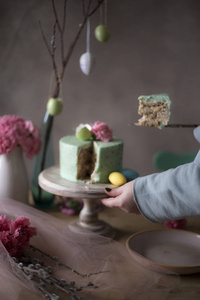 女性手特写从装饰假日餐桌上拍摄自制复活节蛋糕