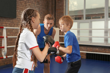 小孩子与训练师在拳击圆环