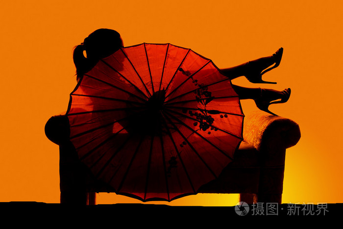 美丽的女人用的伞的剪影