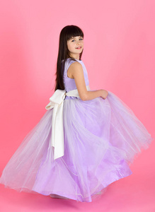 美丽的小女孩模特穿着紫色的礼服