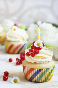 柔和的蛋糕与奶油和莓果和蜡烛光背景